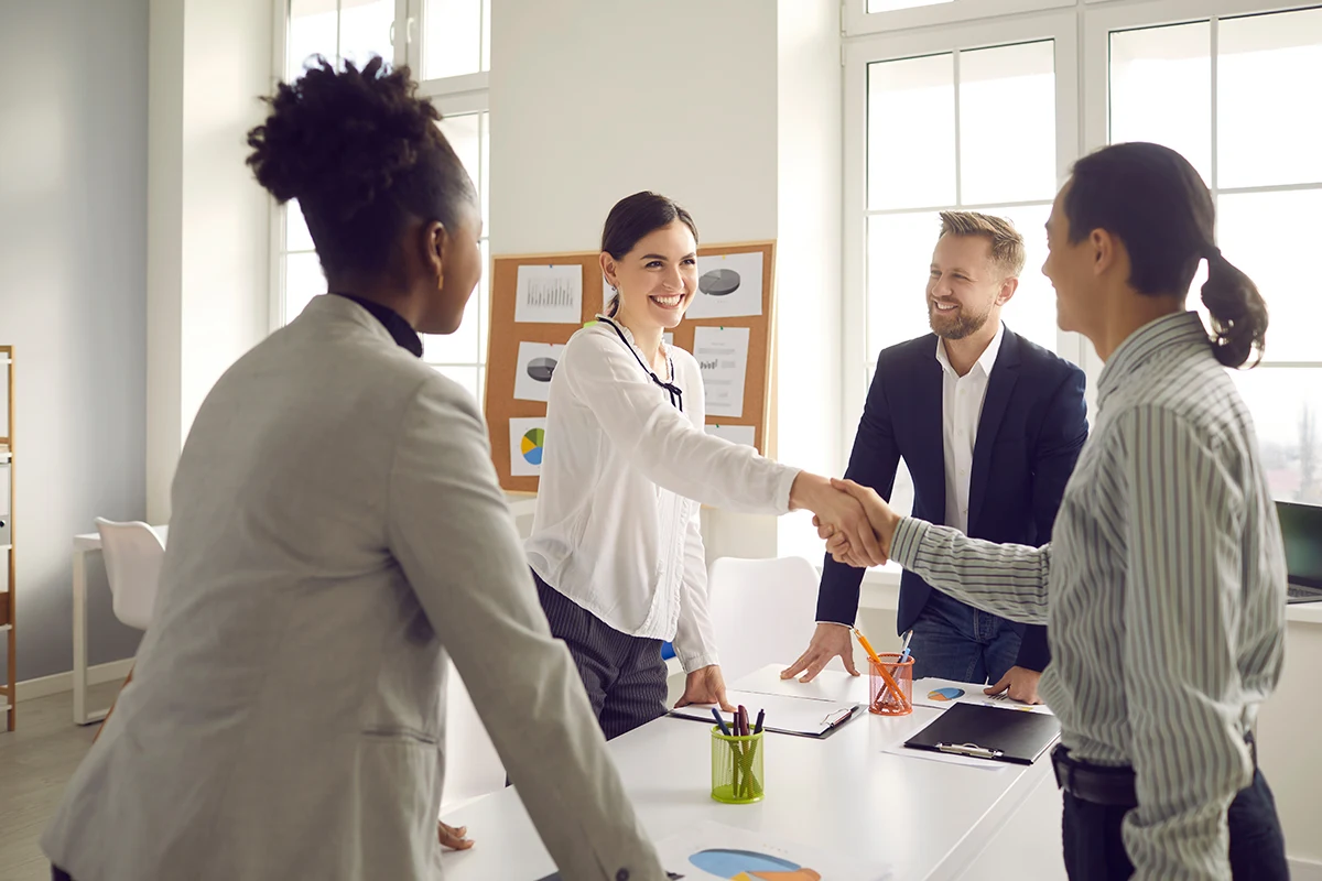 people shaking hands across table